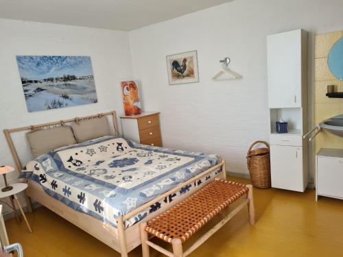 a bedroom with a bed and a bench in it at Sachs Hoyz in Bergen aan Zee