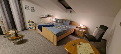 ein Schlafzimmer mit einem Bett, einem Tisch und einem Stuhl in der Unterkunft Ferienwohnung Pia in Mettlach
