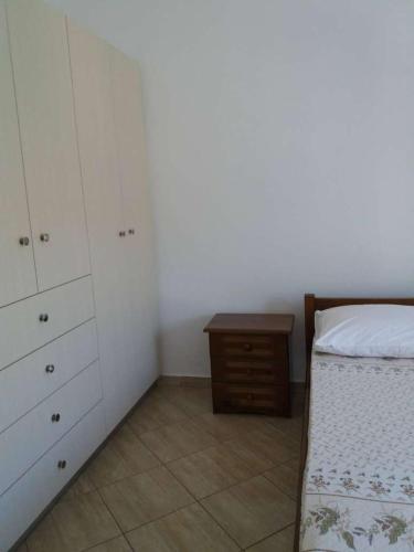 a bedroom with a bed and a dresser and a table at Paradise View in Himare