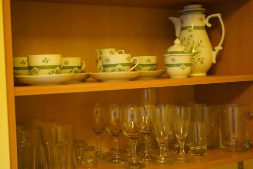 a shelf filled with glasses and a bunch of dishes at Kamil Apartments, Delux A, 65m2 in Karlovy Vary