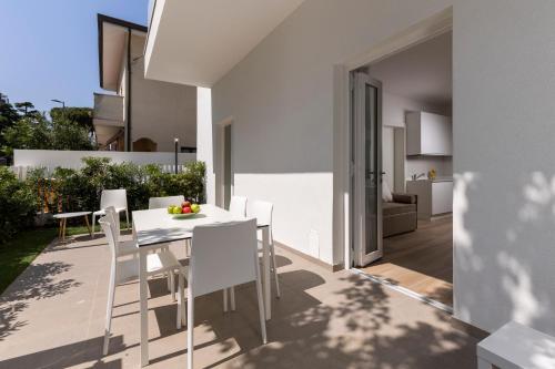 uma cozinha e sala de jantar com uma mesa branca e cadeiras em The Palm Riccione em Riccione