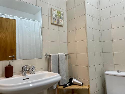 y baño con lavabo, espejo y aseo. en Douro River Cozy Apartments, en Oporto