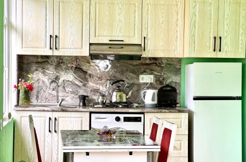 a kitchen with wooden cabinets and a counter top at Secret Garden Guest House in Gabala