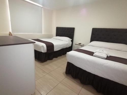 una camera d'albergo con due letti e un bancone di Hotel Cortaderas Arequipa a Yanahuara