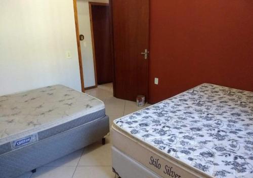 2 camas individuales en una habitación con puerta en Casa Em Penha Sc, en Penha
