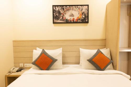a bedroom with a bed with orange and gray pillows at Perfectstayz Value Sagar Near Golden Temple in Amritsar