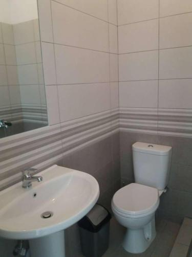 a bathroom with a white toilet and a sink at Paradise View in Himare