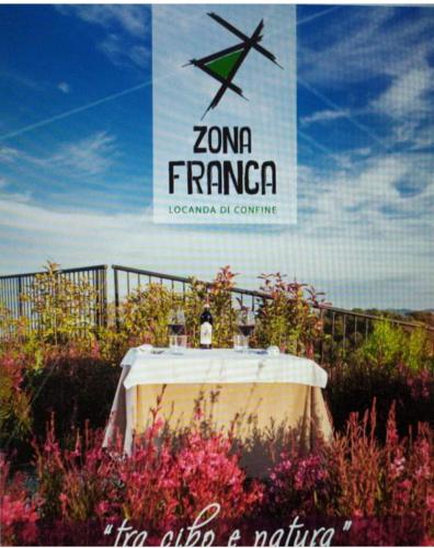 a table in a field of flowers with a sign at Locanda Zona Franca in San Benedetto del Tronto
