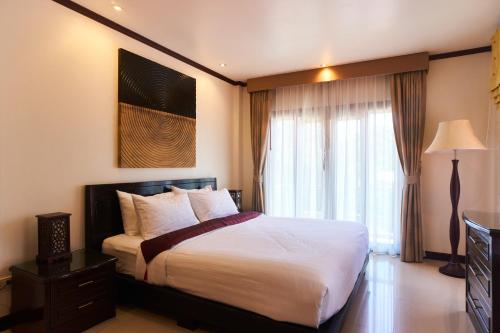 a bedroom with a large bed and a window at Ananda Private Pool Villa, Ao Nang in Krabi town