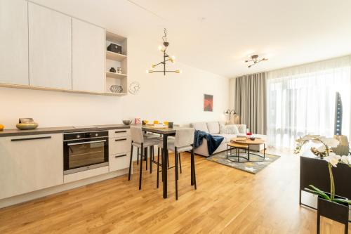 a kitchen and living room with a table and chairs at Citygate Sunset balcony in Tartu