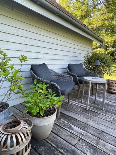 two chairs and a table on a wooden deck at Ecrin de Vizaille in Toucy
