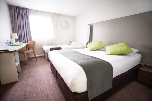 una camera d'albergo con 2 letti e una scrivania di Campanile Hotel Northampton a Northampton