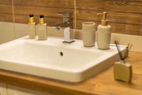 a bathroom sink with five soap bottles on it at Chalupa Babí 113 in Trutnov