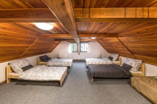 a attic room with three beds and couches in it at Chalupa Babí 113 in Trutnov