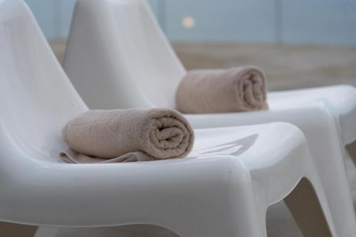 zwei Handtücher sitzen auf einem weißen Stuhl in der Unterkunft "BlueVedere" Sea View Luxury Villa in Agia Pelagia