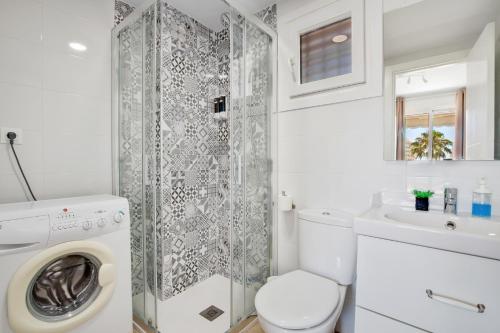 baño blanco con lavadora y lavamanos en Vistamarina B201 By IVI Real Estate, en Torremolinos