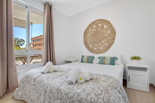 a bedroom with a bed with white sheets and a window at Vistamarina B201 By IVI Real Estate in Torremolinos