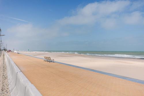 un banco sentado en la playa cerca del océano en Modern studio near the beach, en Ostende