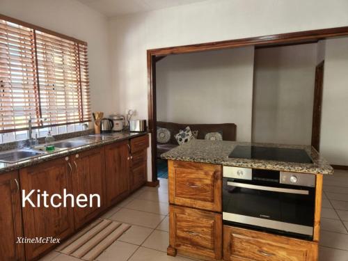 a kitchen with a sink and a stove top oven at Captain's Villa in Takamaka