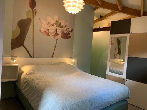 a bedroom with a bed and a painting of flowers on the wall at Silo 161 in Ruinerwold