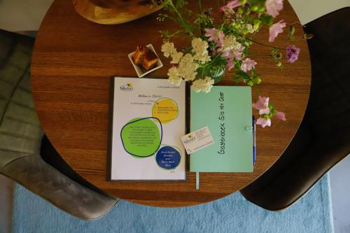 a wooden table with flowers and papers on it at Silo 161 in Ruinerwold