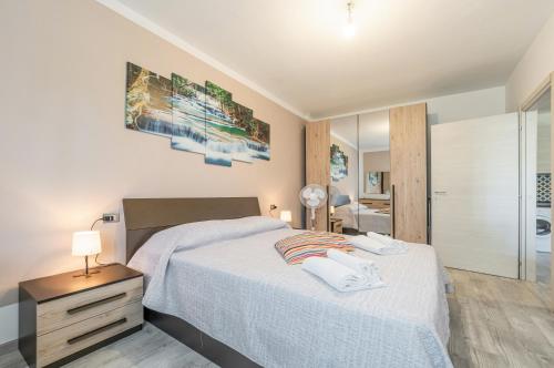 - une chambre avec un grand lit et une salle de bains dans l'établissement Domus Lucis Apartment Terrace & Private Parking, à Marinella di Sarzana