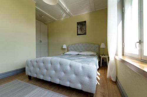 a bedroom with a white bed with a tufted mattress at Verona Apartments - Paide in Paide