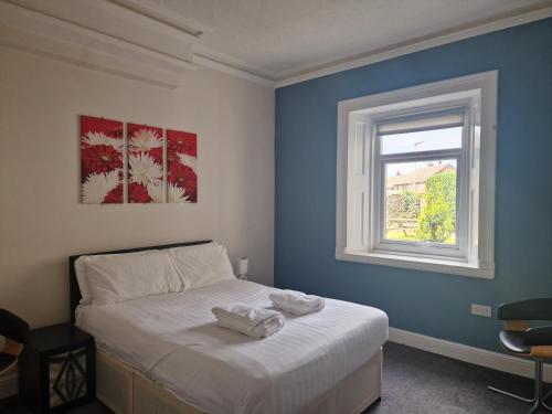 een slaapkamer met een wit bed en een raam bij 2 The Green, exceptional large house, sea views loads of bathrooms in Seaton Carew