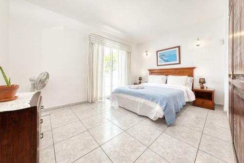 a white bedroom with a bed and a window at Casa El Paraiso in Tías