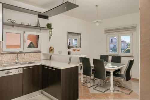 a kitchen and dining room with a table and chairs at House Leonardo in Galovac