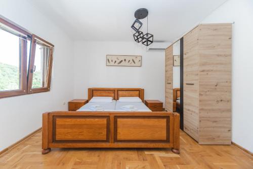 ein Schlafzimmer mit einem Holzbett in einem Zimmer in der Unterkunft Guest House Zuber in Budva