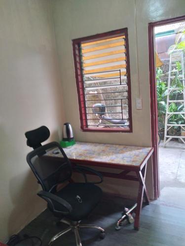 TaytayにあるTerisitaPlace - BamboRoomのデスク、椅子、窓が備わる客室です。