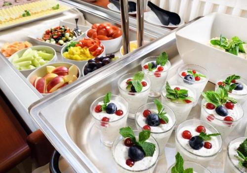 a buffet filled with appetizers and fruit in small dishes at Hotel Srdiečko in Tale