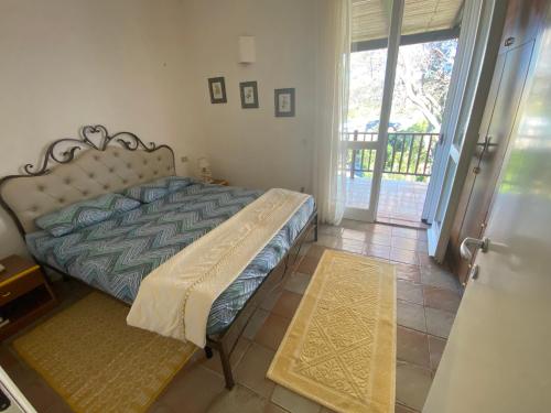 カンニジョネにあるAppartamenti La Suaraのベッドルーム1室(ベッド1台付)、スライド式ガラスドアが備わります。
