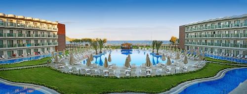 un gran patio con sillas y una fuente entre 2 edificios. en My Ella Bodrum Resort & Spa, en Muğla