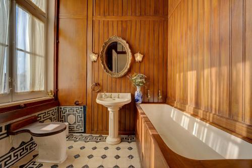 a bathroom with a tub and a toilet and a sink at Palácio das Especiarias in Lisbon
