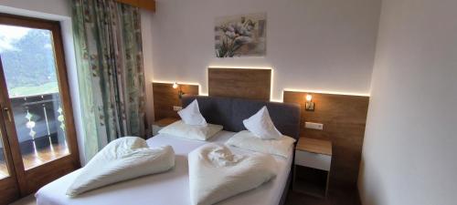 pokój hotelowy z łóżkiem i oknem w obiekcie Zimmervermietung Gröberhof w mieście Schenna