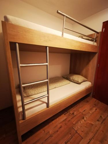 a bunk bed in a room with wooden shelves at Koliba Pod Skalami in Súľov-Hradná