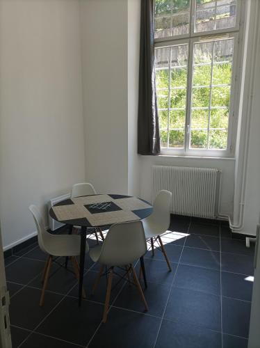 une salle à manger avec une table et des chaises et une fenêtre dans l'établissement O'Couvent - Appartement 79 m2 - 2 chambres - A512, à Salins-les-Bains