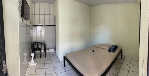 ウベルランジアにあるSuítes Algthのベッドとテーブル付きの小さな部屋