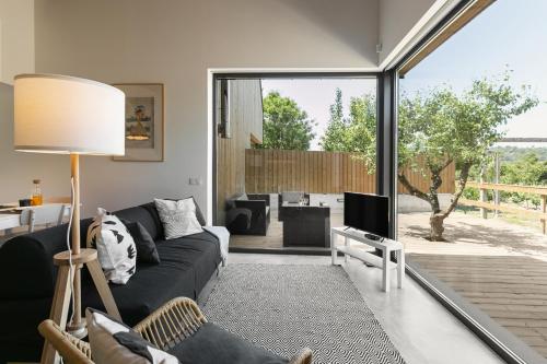 a living room with a black couch and a television at Villa Arneiro II in Vimeiro
