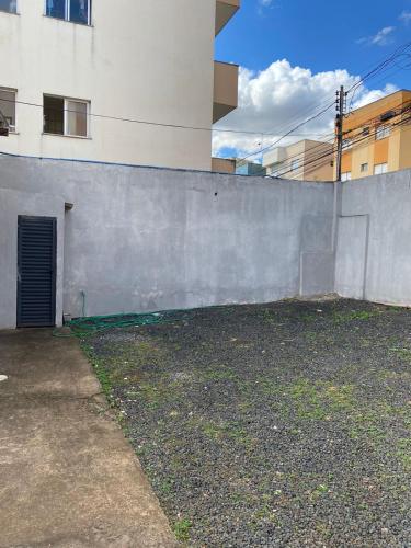 a concrete wall next to a building with a door at Suítes Algth in Uberlândia