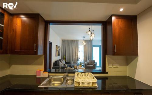 a kitchen with a sink and a living room at Luxury 2 Bedroom Suite with Full Burj Khalifa View in Dubai