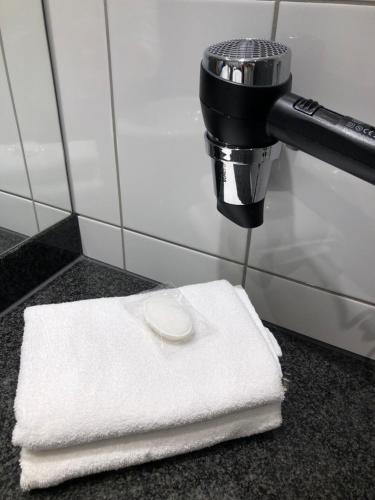 a white towel sitting on a counter next to a faucet at Vienna House Easy by Wyndham Berlin Prenzlauer Berg in Berlin