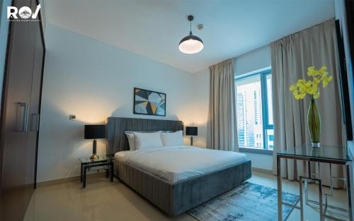Luxury 2 Bedroom Suite with Full Burj Khalifa View في دبي: غرفة نوم بسرير ونافذة كبيرة