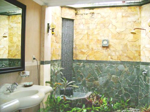 a bathroom with a sink and a shower with a sink at Swaloh Resort & Spa in Kalangbret
