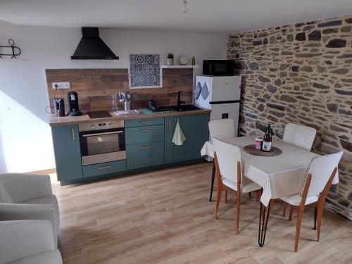 une cuisine et une salle à manger avec une table et des chaises dans l'établissement Gîte charmant typique Breton Ti Quartier, à Pordic