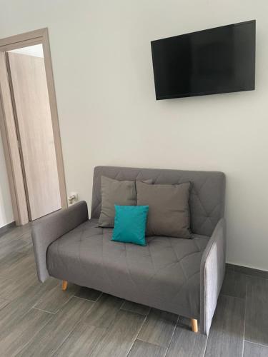 a grey couch with a blue pillow on it at Juli’s Suites in Mérikhas