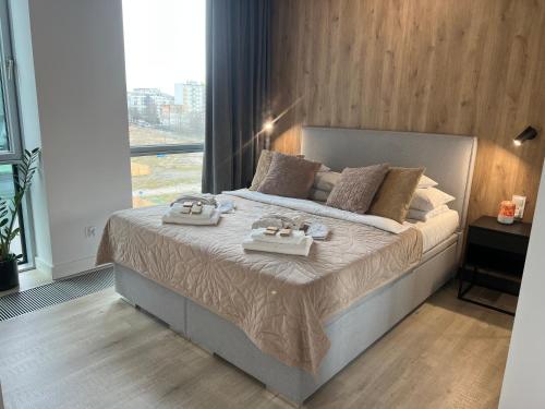 a bedroom with a bed with two trays on it at Modern Vero Apartments Yacht Park in Gdynia