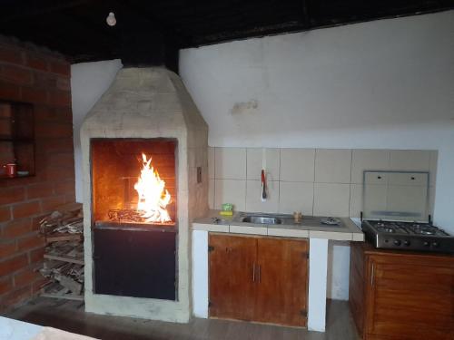 a kitchen with an oven with a fire in it at Casa Verde Descanso in Baños
